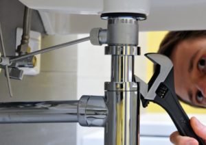 plumber checking for leaks under the sink