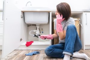 woman calling a plumber for a plumbing emergency