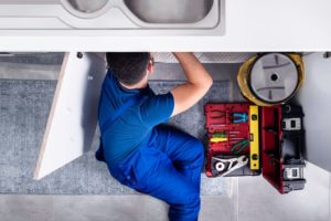 plumber working under the sink