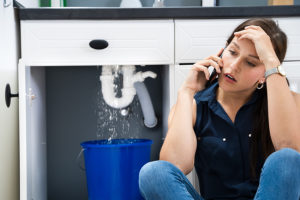 woman calling plumber with an emergency